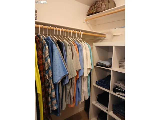 a view of walk in closet with clothes and shoes
