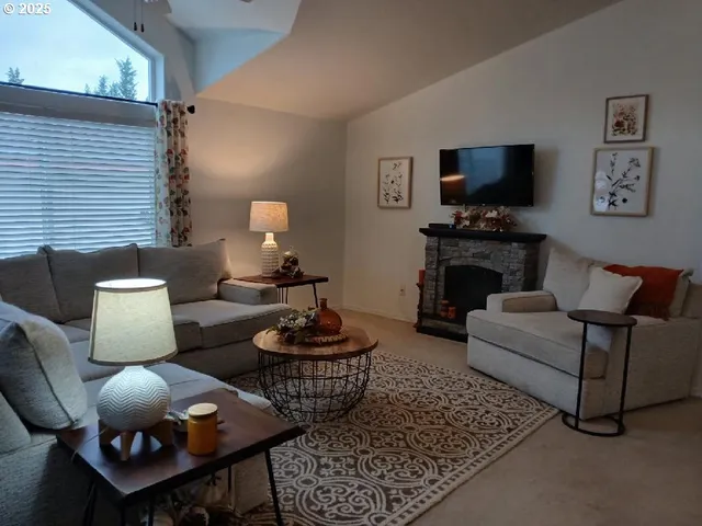 a living room with furniture a flat screen tv and a fireplace