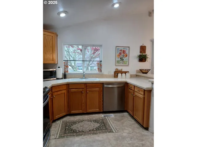 a kitchen with granite countertop a sink cabinets and window