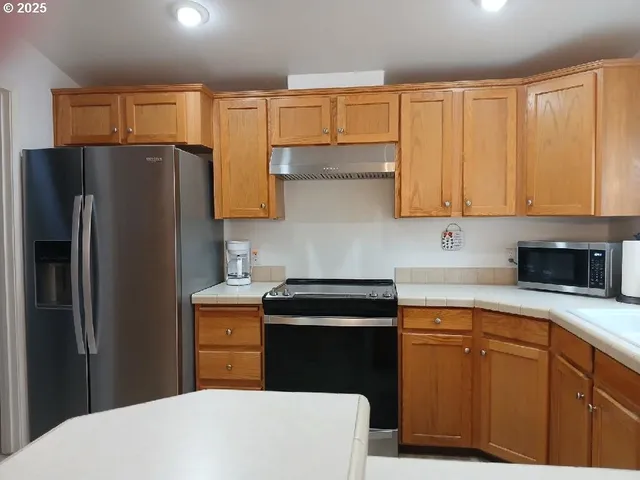 a kitchen with a refrigerator sink and cabinets