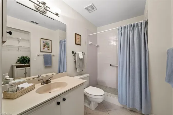 a bathroom with a double vanity sink toilet and shower