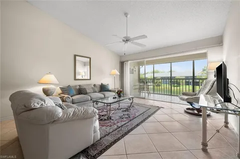 a living room with furniture and a floor to ceiling window