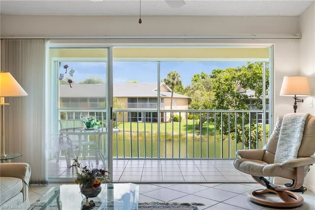 a living room filled with furniture and a floor to ceiling window