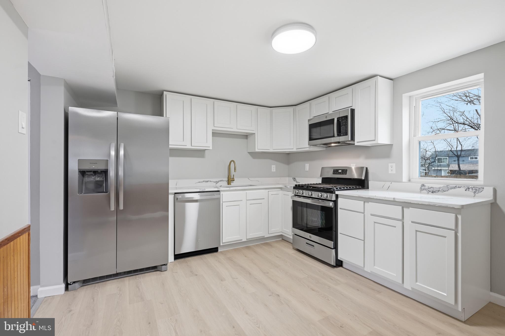 22 Raintree Drive New Castle, DE 19720 - Photo 7 of 29 a kitchen with stainless steel appliances granite countertop a stove a sink and a refrigerator