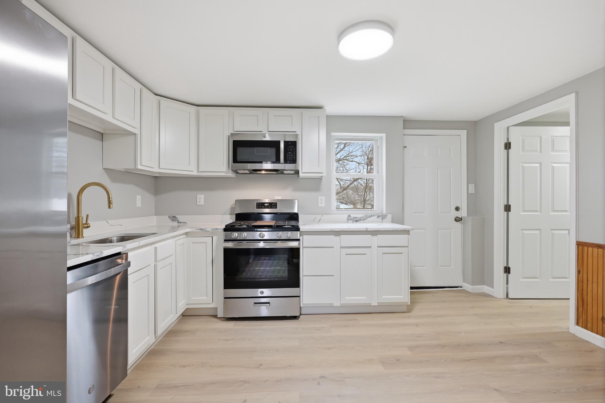 22 Raintree Drive New Castle, DE 19720 - Photo 9 of 29 a kitchen with sink a microwave and cabinets