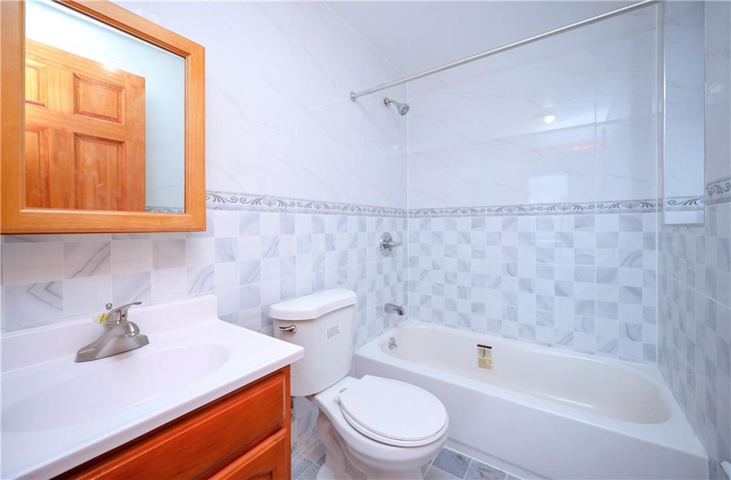 1270 64th Street, Unit 1B Brooklyn, NY 11219 - Photo 12 of 13 a bathroom with a sink a toilet and shower