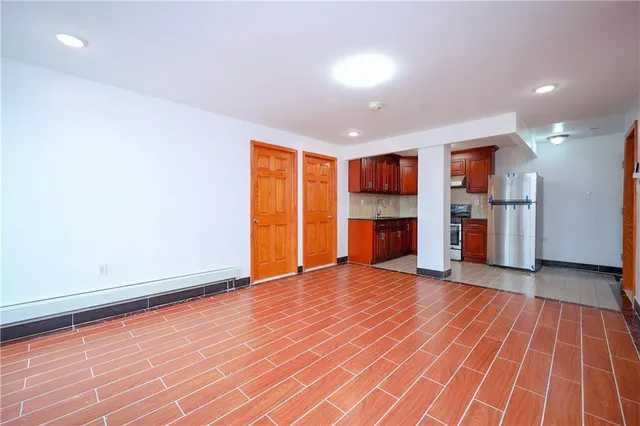 wooden floor in an empty room with a kitchen