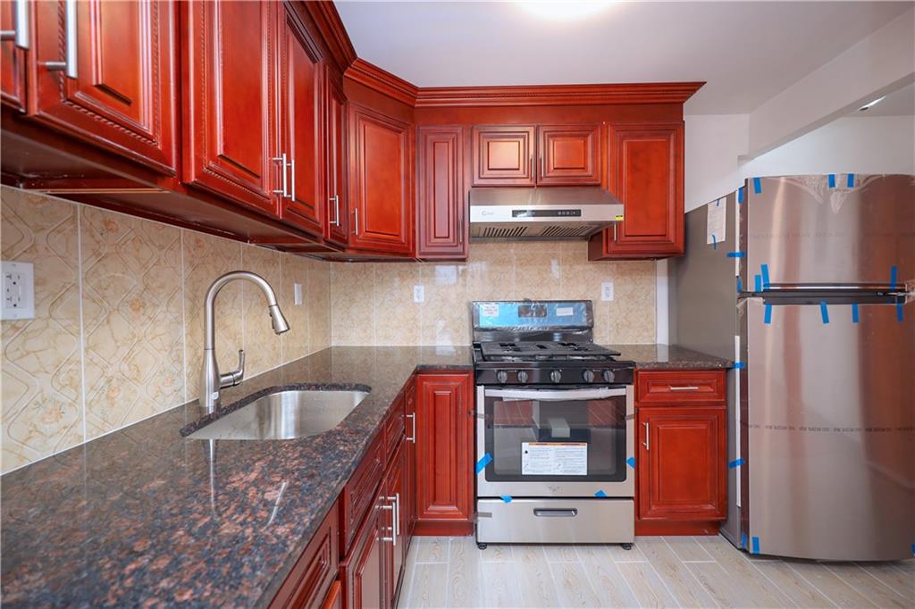 1270 64th Street, Unit 1B Brooklyn, NY 11219 - Photo 6 of 13 a kitchen with stainless steel appliances granite countertop a stove refrigerator sink and cabinets