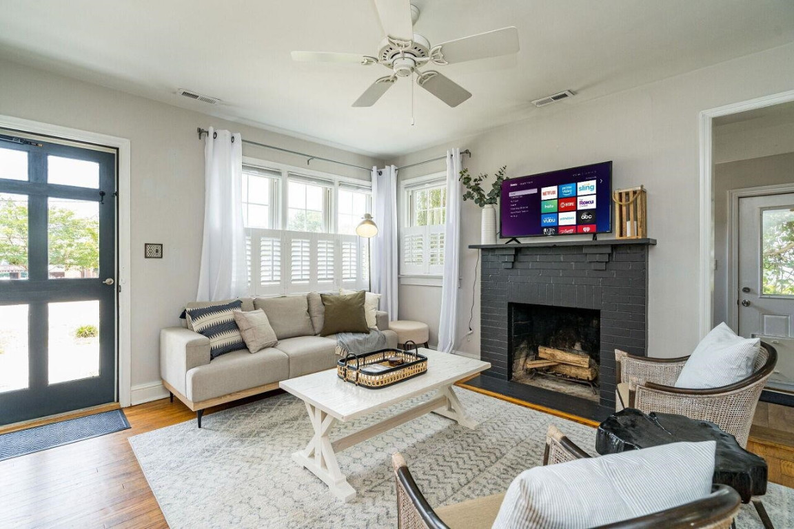 620 East Whitaker Mill Road Raleigh, NC 27608 - Photo 3 of 28 a living room with furniture a flat screen tv and a fireplace