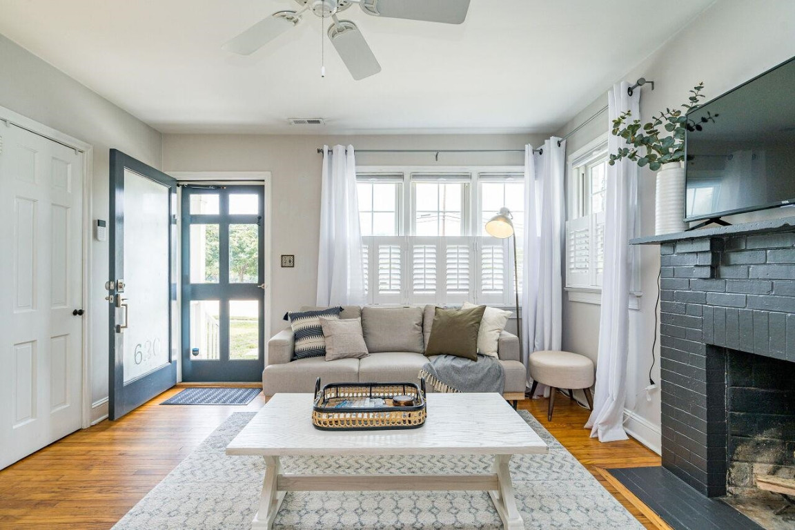 620 East Whitaker Mill Road Raleigh, NC 27608 - Photo 4 of 28 a living room with furniture a fireplace and a chandelier