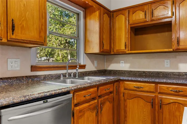 a kitchen with granite countertop cabinets stainless steel appliances granite counter tops and a window