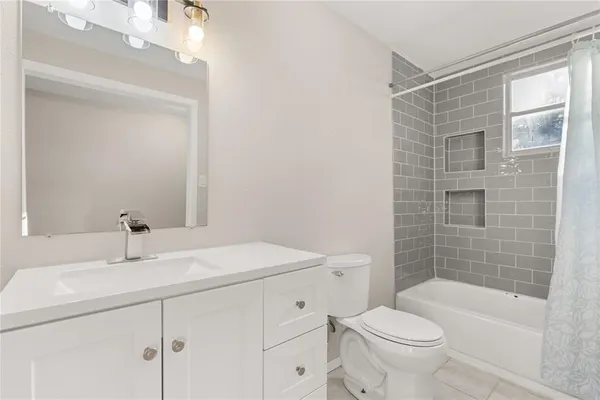 a bathroom with a sink toilet vanity and tub
