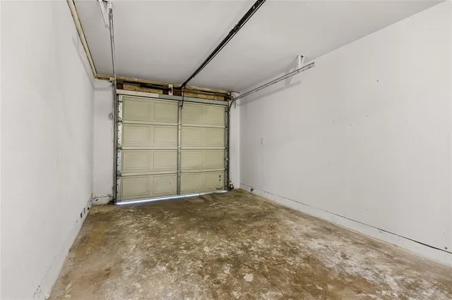 a view of an empty room with window and a chandelier fan