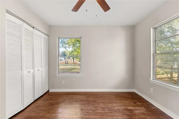 a view of an empty room with chandelier fan and a window