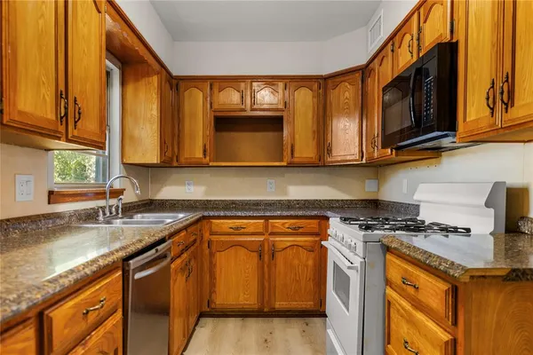 a kitchen with stainless steel appliances granite countertop a sink stove and microwave