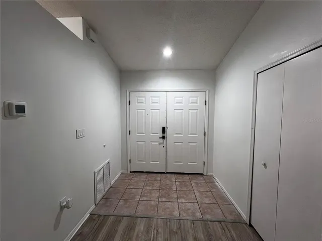 a view of empty room with wooden floor