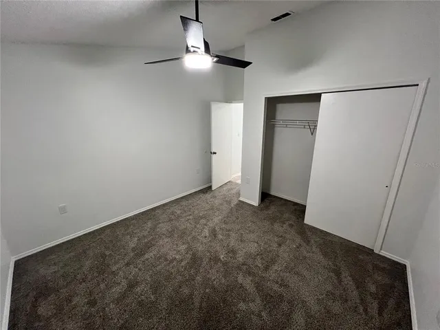 an empty room with a ceiling fan and a window