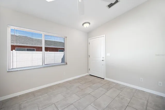 an empty room with a kitchen and a window