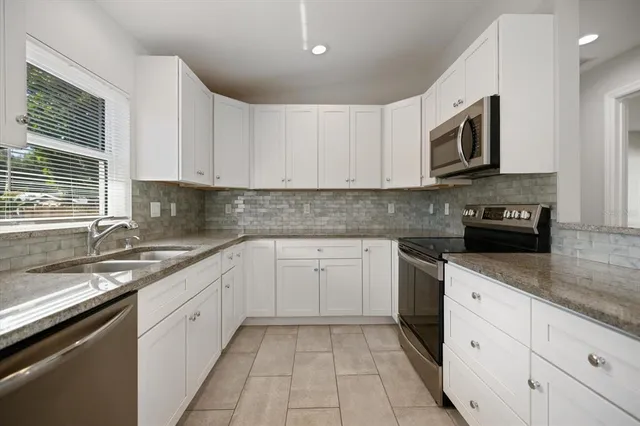 a kitchen with granite countertop a stove and a microwave