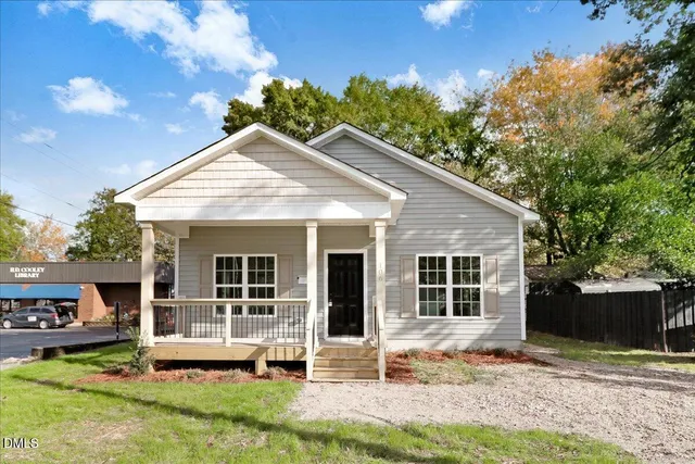 a view of a house with a yard and sitting area