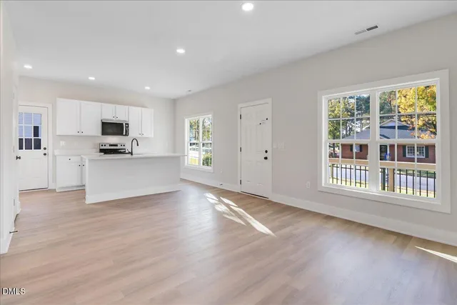 a view of a kitchen with a sink a refrigerator and window