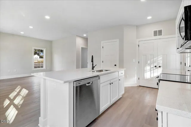 a large kitchen with stainless steel appliances granite countertop a lot of counter space and wooden floor