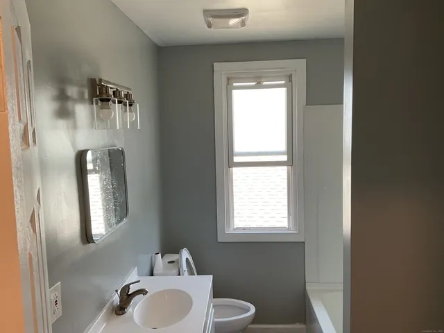 a bathroom with a sink toilet and mirror