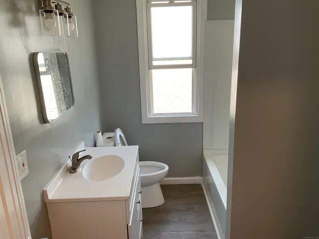 a bathroom with a sink toilet and a mirror