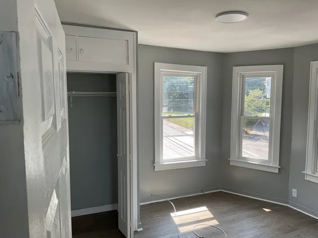 an empty room with windows and closet