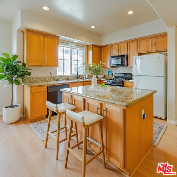 2155 Associated Road Fullerton, CA 92831 - Photo 10 of 47 a kitchen with stainless steel appliances granite countertop sink stove refrigerator and cabinets
