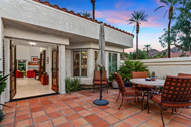 a view of a dinning table and chairs in patio of the house