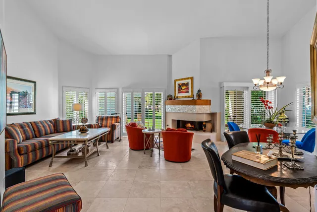 a living room with furniture a fireplace and a chandelier