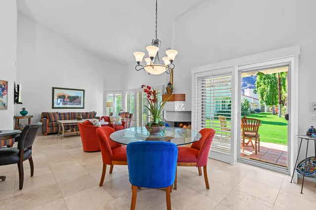 a dining room filled with furniture a chandelier and a rug