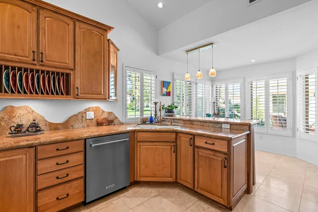 a kitchen with granite countertop a sink cabinets and window
