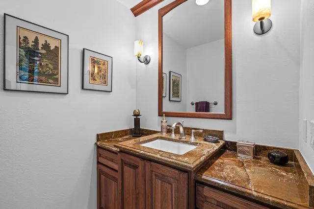 a bathroom with a granite countertop sink and a mirror