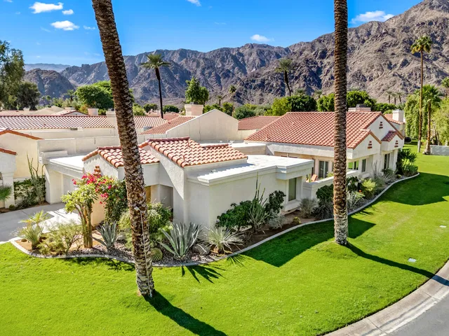 a aerial view of a house with a big yard and potted plants