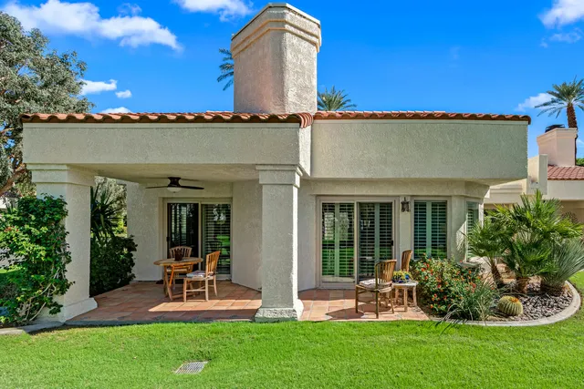 a front view of a house with a yard and palm trees