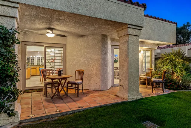 a view of a house with backyard and sitting area