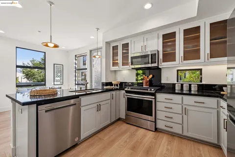 a kitchen with stainless steel appliances granite countertop a stove and cabinets