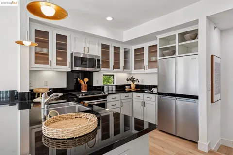 a kitchen with stainless steel appliances granite countertop a stove and a refrigerator