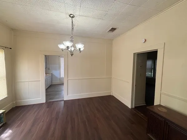a view of a room with wooden floor and chandelier