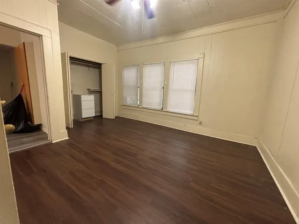 an empty room with wooden floor and a fireplace