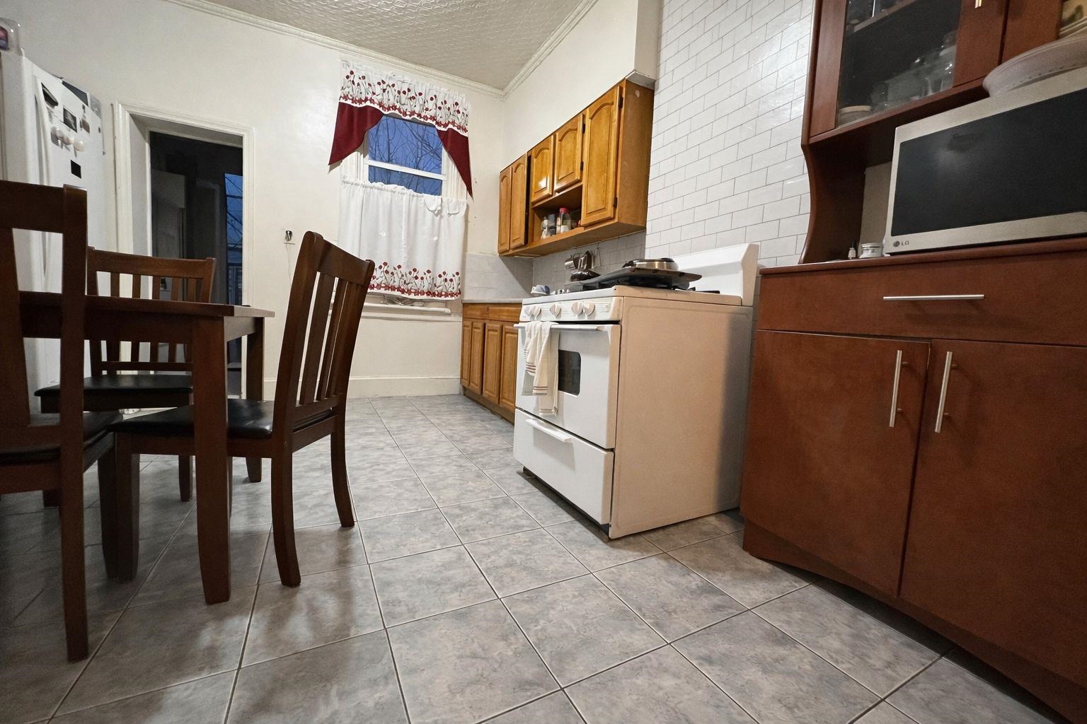 811 24th Street Union City, NJ 07087 - Photo 2 of 4 a view of a dining room with furniture and a kitchen view