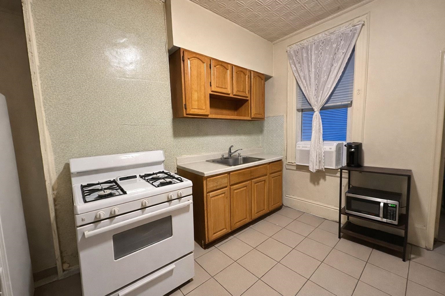 811 24th Street Union City, NJ 07087 - Photo 3 of 4 a kitchen with a stove and a microwave