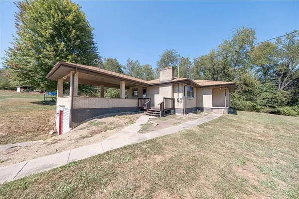 a view of a house with backyard and trees