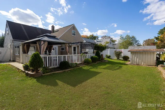 a view of a house with a big yard plants and large trees