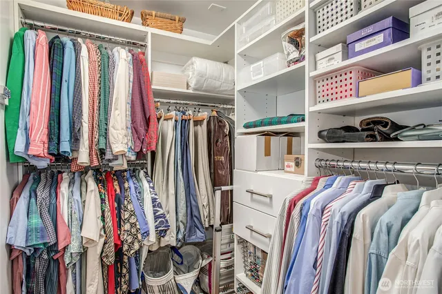 a view of walk in closet with clothes and shoes