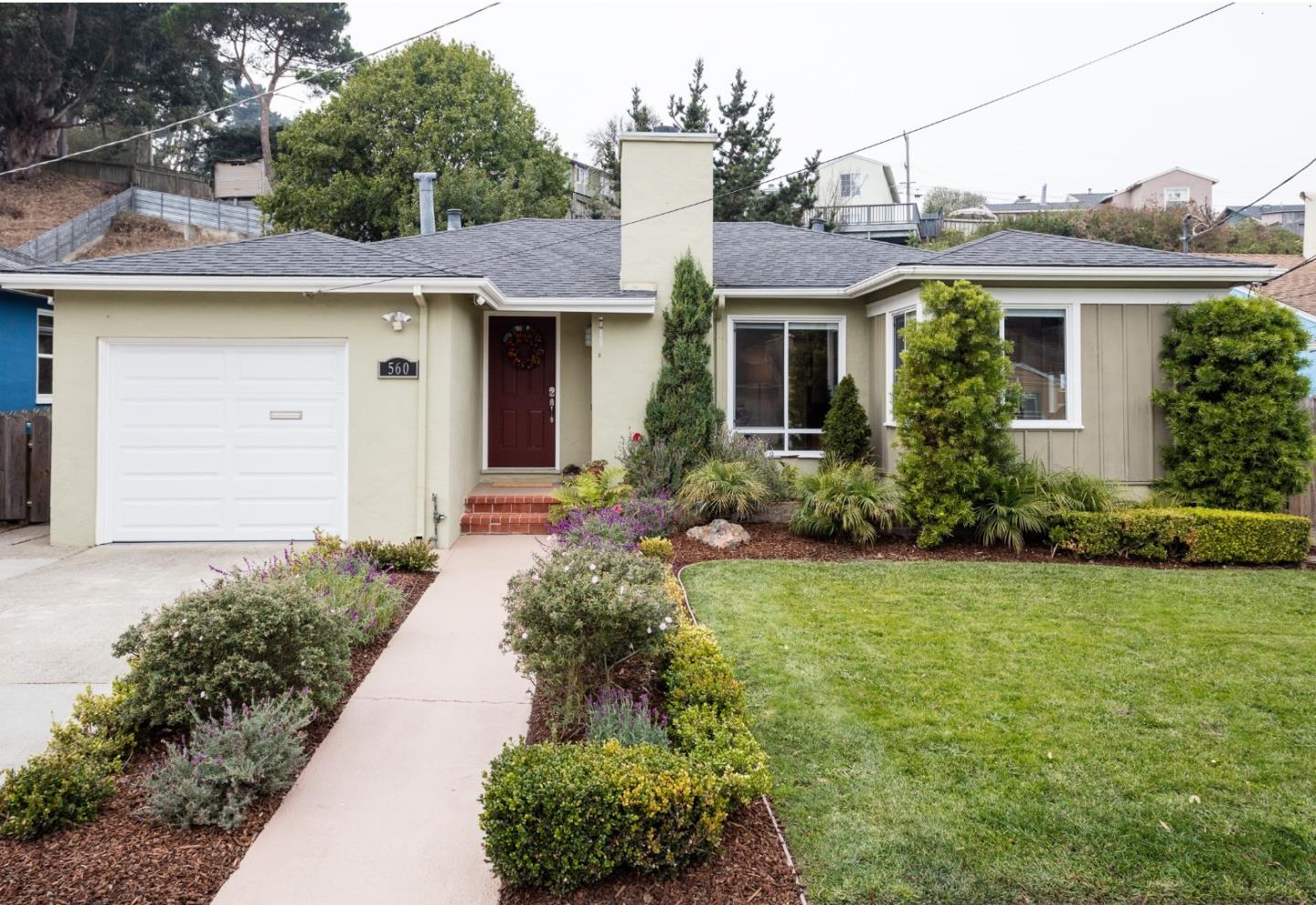 a front view of house with yard and trees around