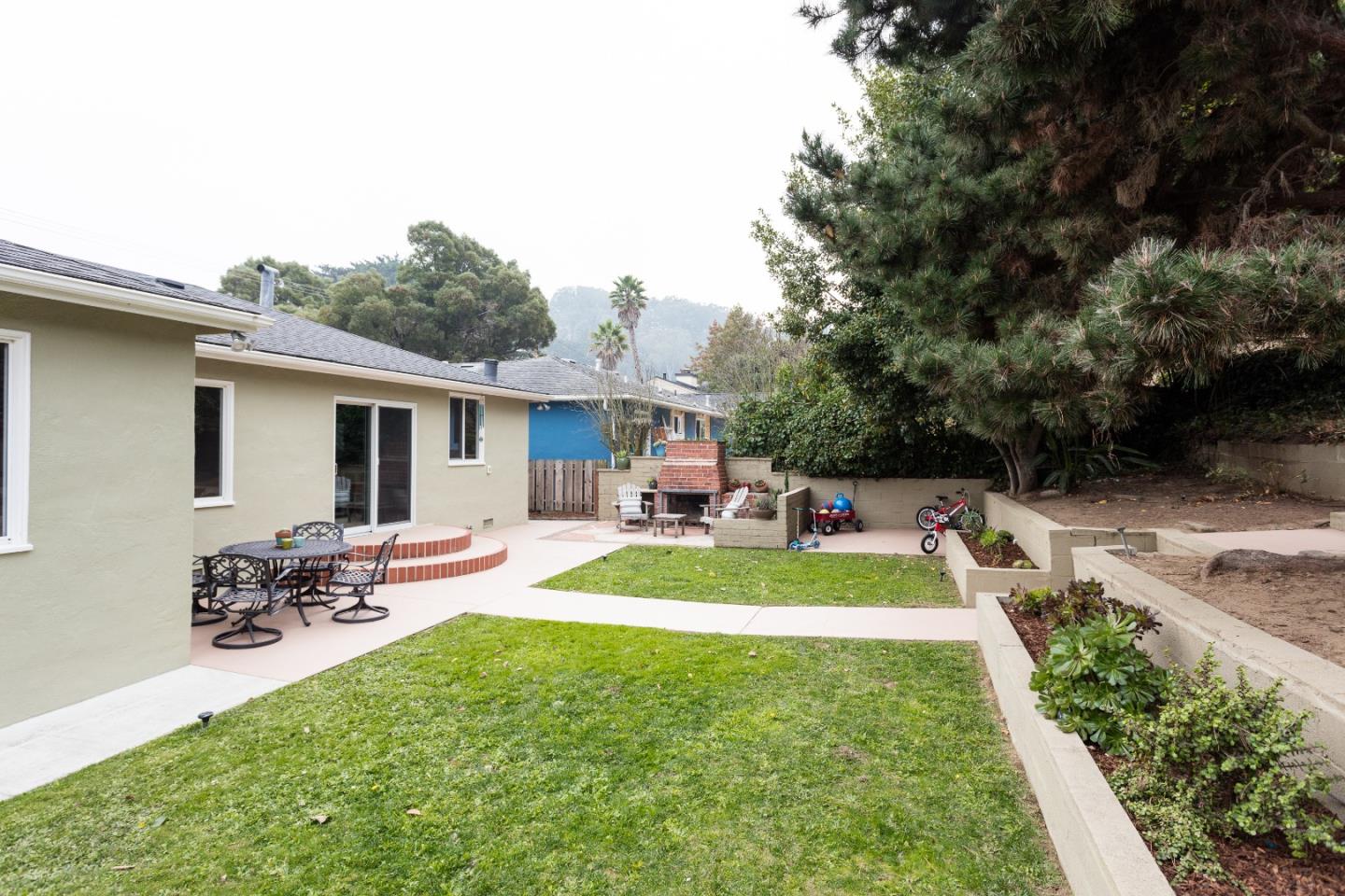 560 Macarthur Drive Daly City, CA 94015 - Photo 17 of 18 a view of a backyard with table and chairs potted plants and a palm tree