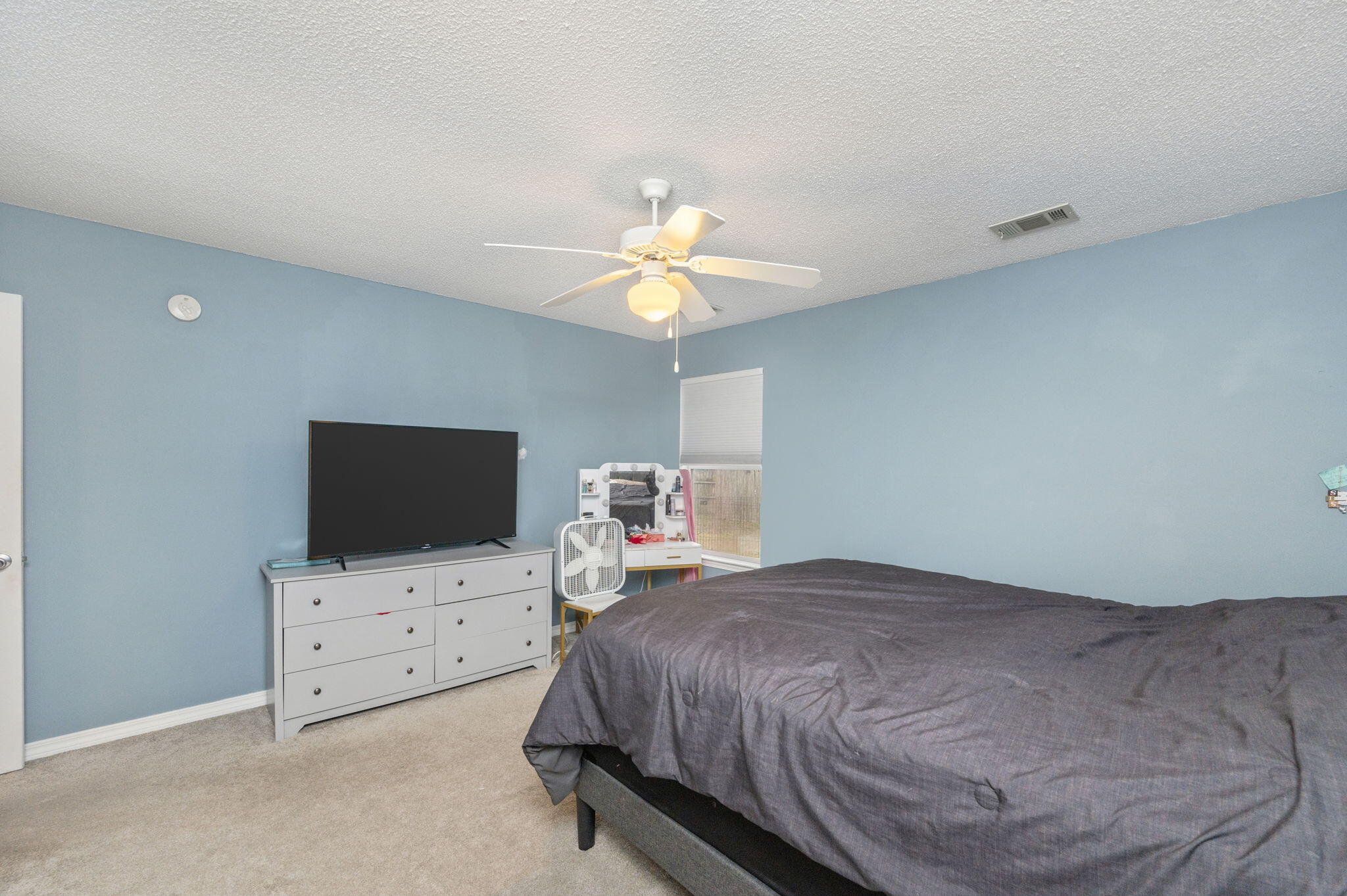 2139 Tom Street Navarre, FL 32566 - Photo 15 of 32 a bedroom with bed and flat tv screen on dresser
